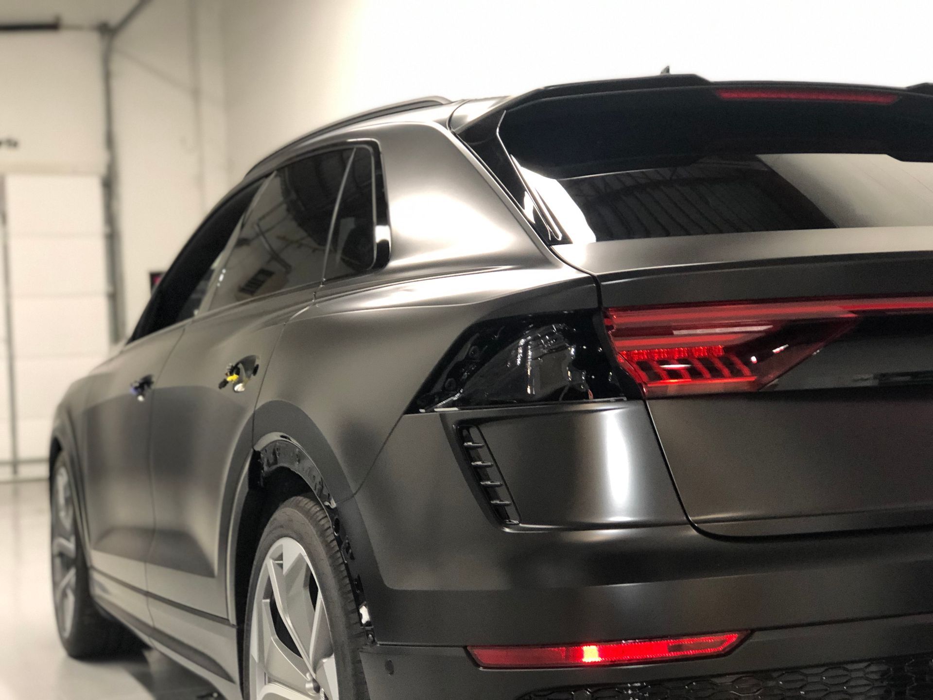 A matte dark grey Audi e-tron Sportback parked inside a bright, clean garage.