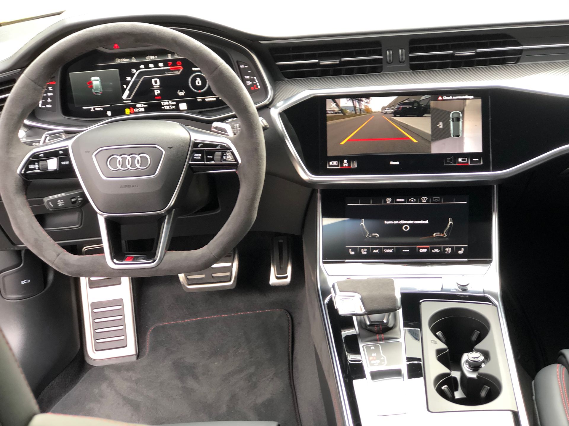 The interior of an Audi vehicle, focusing on the steering wheel, digital dashboard, and infotainment screens.