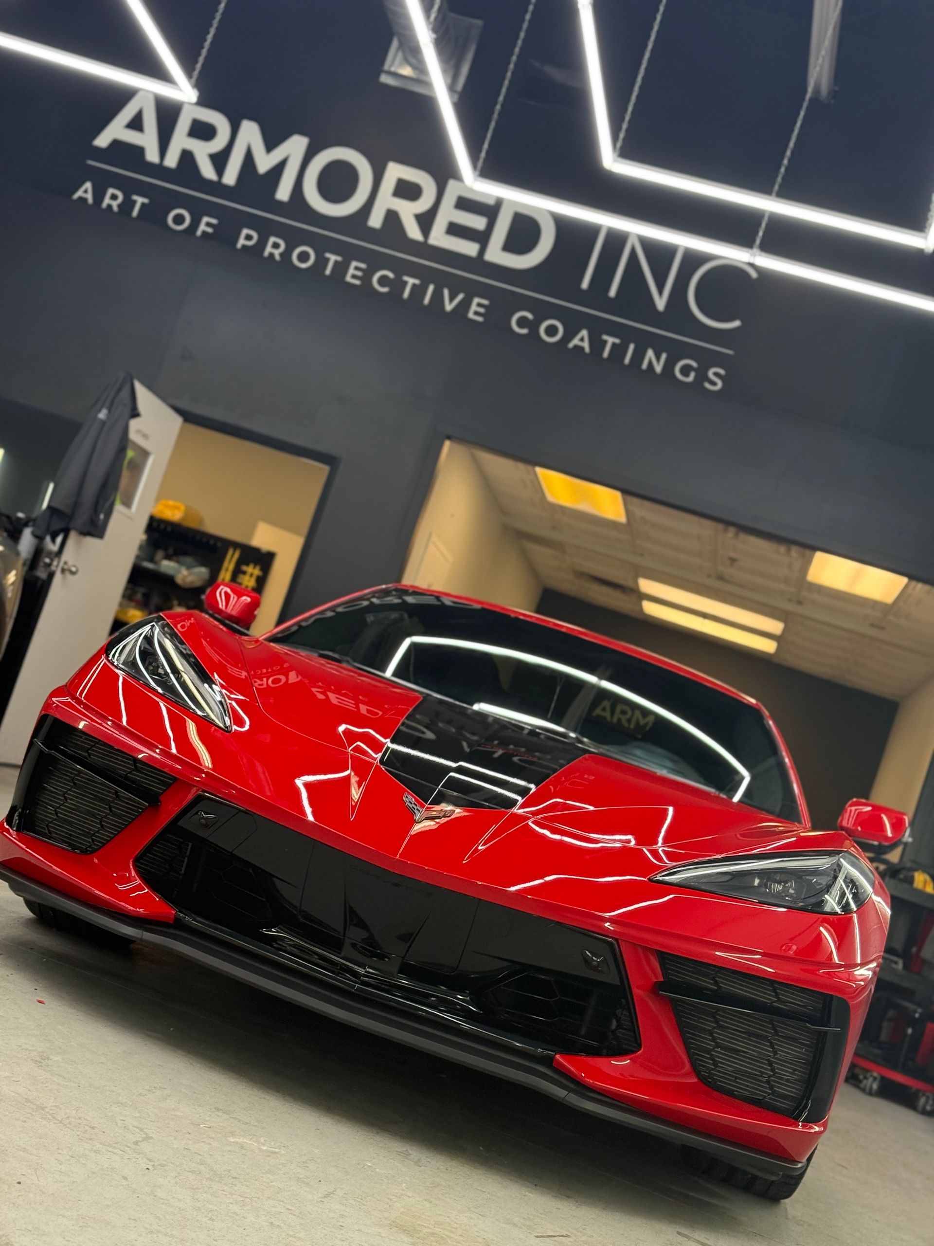 A red Chevrolet Corvette parked in a garage under 