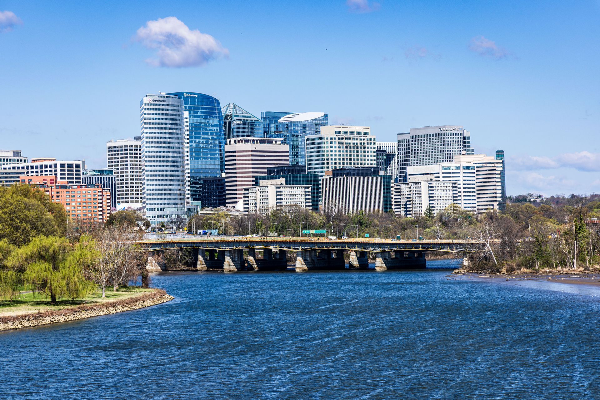River with bridge and modern city skyline under a blue sky