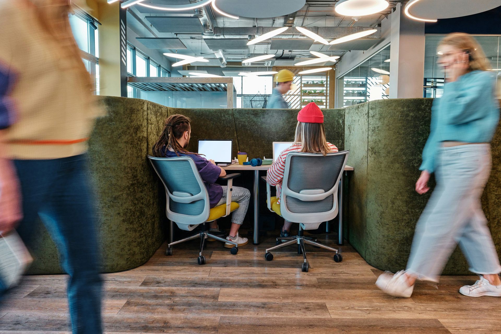 A group of people are sitting at desks in front of computers.