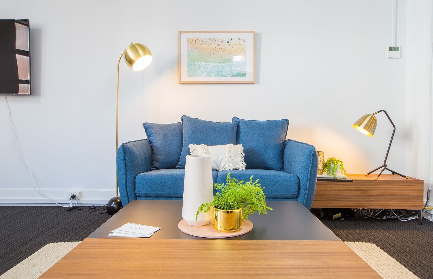 A living room with a blue couch and a coffee table.