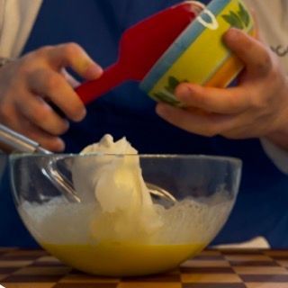 Una persona sta mescolando qualcosa in una ciotola con un cucchiaio