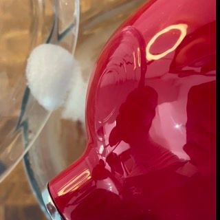 Un primo piano di un oggetto rosso con il riflesso di una persona