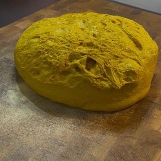 Polpastrelli che stendono delicatamente l'impasto dal bordo verso il centro