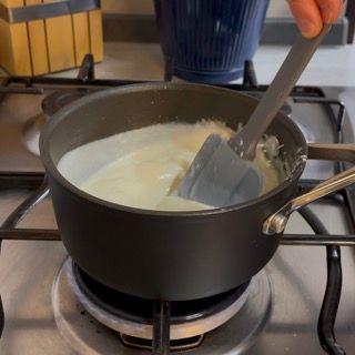 Una persona sta mescolando una pentola di zuppa con una spatola
