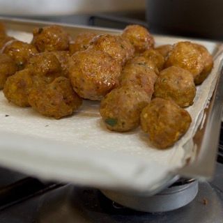 Un mucchio di polpette sono adagiate su un tovagliolo di carta.