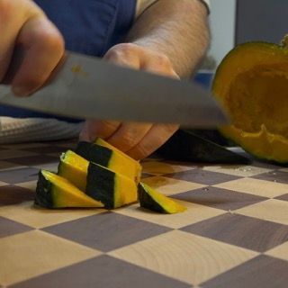 Zucca tagliata a pezzi regolari su un tagliere.