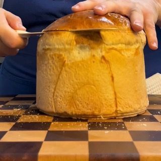 Coltello a sega posizionato per incidere la calotta del panettone gastronomico.