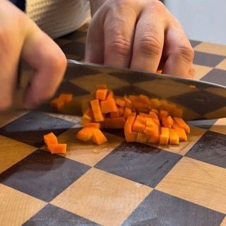 Patate e carote pelate pronte sul tagliere per la farcitura vegetale.