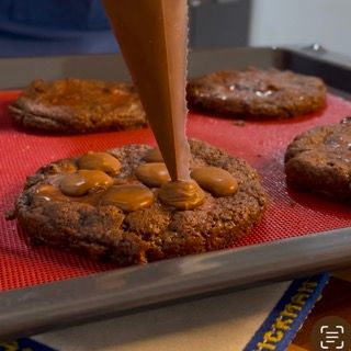Una persona sta versando la salsa al cioccolato su un biscotto