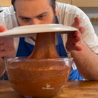 Un uomo tiene un piatto sopra una ciotola di cibo
