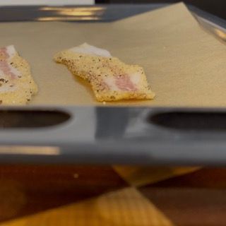 Guanciale disposto su una teglia con carta da forno