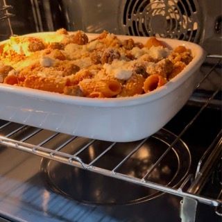 Una teglia piena di maccheroni e formaggio sta cuocendo in forno