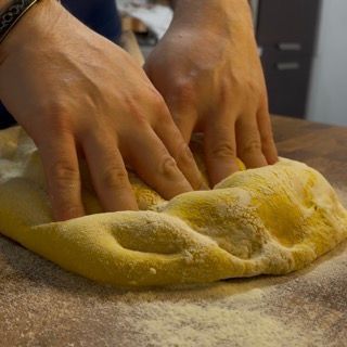 Base della pizza stesa e pronta per essere messa in teglia