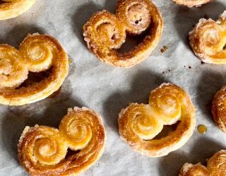 Un mucchio di pasticcini a forma di cuore sono appoggiati su un tavolo