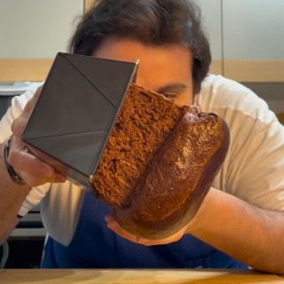 Un uomo tiene un pezzo di pane davanti al viso