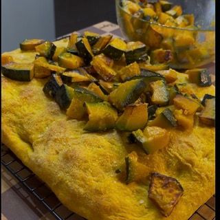 Pezzi di zucca arrostita e burrata fresca distribuiti sulla pizza