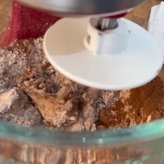 Un mixer mescola gli ingredienti in una ciotola di vetro.