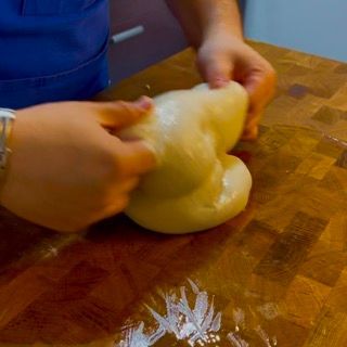 Mani che eseguono un giro di pieghe sull'impasto