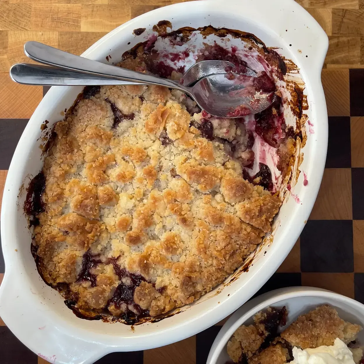 Pirofila da forno con crumble ai frutti di bosco dorato e croccante. Ricetta crumble ai frutti rossi