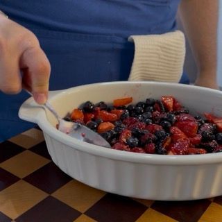 Base di mirtilli e lamponi pronta nella pirofila in attesa della copertura croccante del crumble perfetto.