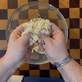 Consistenza finale a grosse briciole dell'impasto al burro per il perfetto croccante crumble ai frutti rossi.