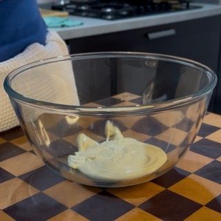 Cioccolato bianco fuso fluido pronto per l'emulsione della preziosa ganache per il crumble ai frutti rossi.