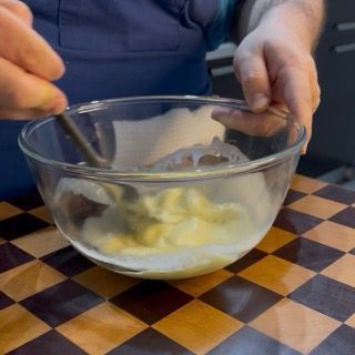 Mescolamento energico del nucleo centrale di cioccolato per il topping lucido della ricetta crumble perfetta.