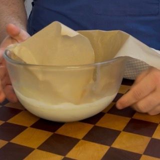Riposo in frigorifero della crema coperta da pellicola a contatto per far cristallizzare il burro di cacao.