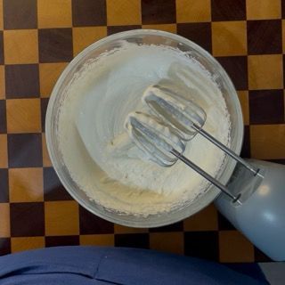 Estrazione della ganache bianca ben fredda dal frigorifero dopo 8 ore di riposo, pronta per la montatura.