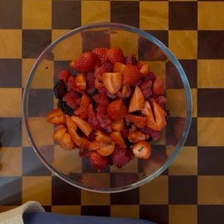 Lavaggio accurato dei mirtilli e lamponi in ciotola per preparare il crumble ai frutti di bosco fresco.