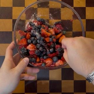 Mirtilli, more e lamponi ben conditi e lucidi per la base della ricetta crumble ai frutti di bosco.