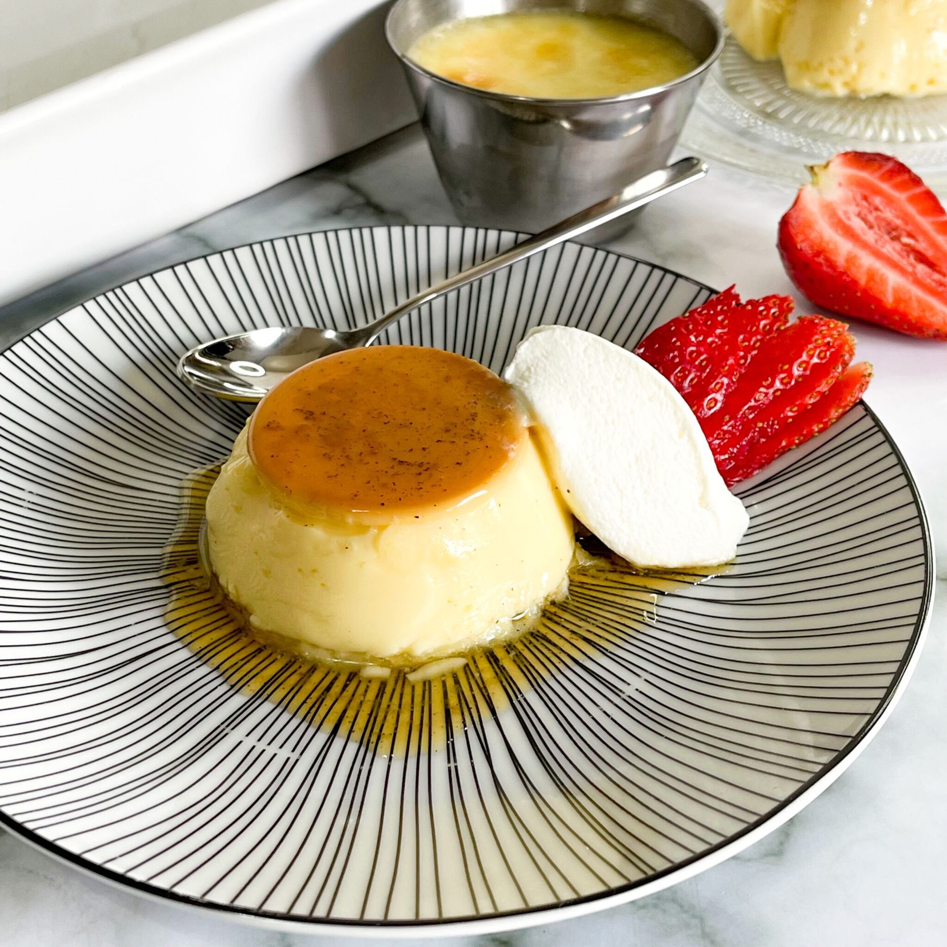 Un piatto di dessert con panna montata e fragole su un tavolo.