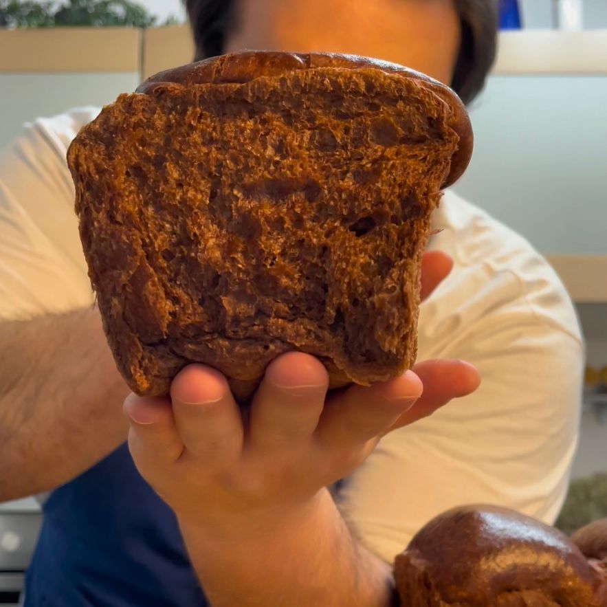Una persona tiene in mano un pezzo di pane integrale
