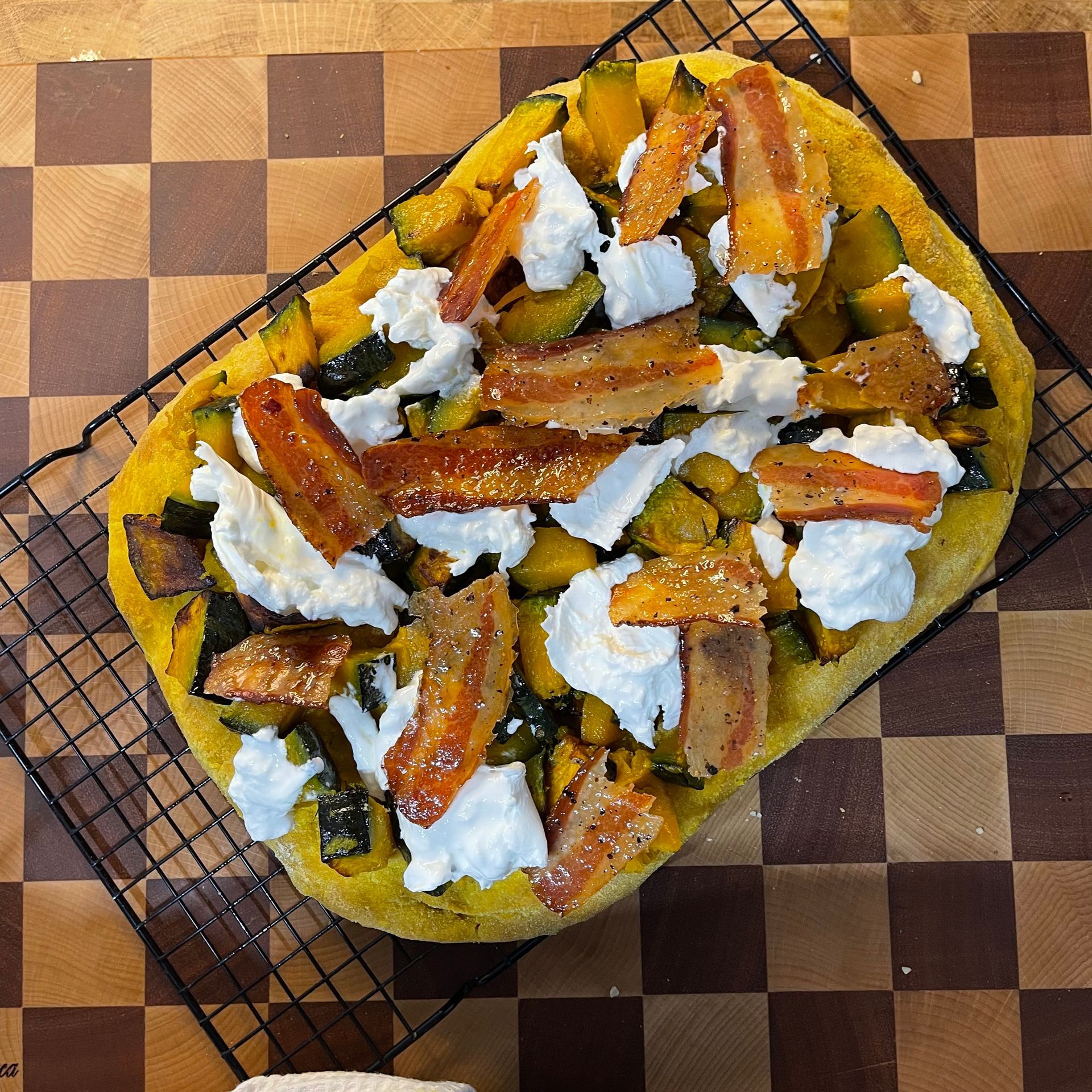 Pizza alla zucca gourmet con burrata fresca, guanciale croccante e foglie di basilico, appena sforna