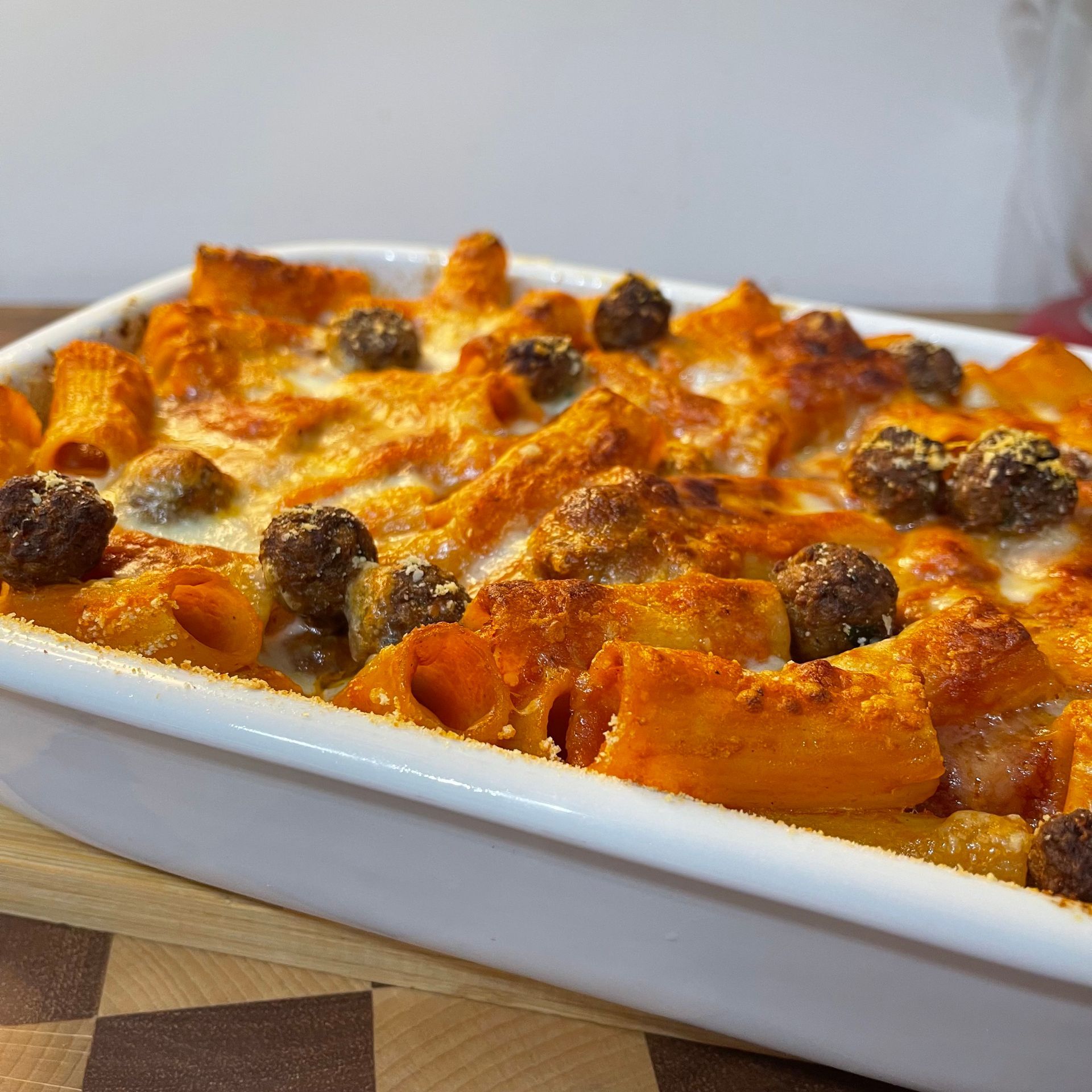 Una casseruola bianca piena di pasta e polpette