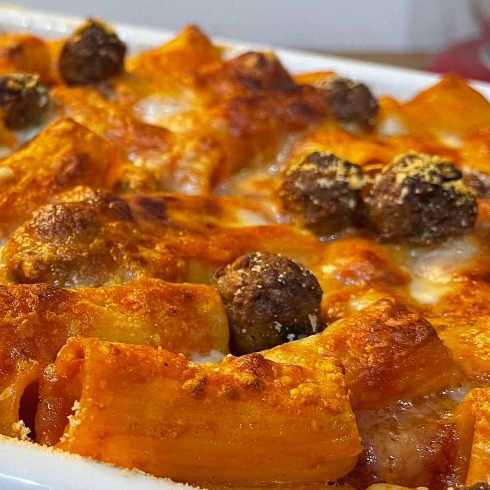 Primo piano di una teglia piena di pasta e polpette.