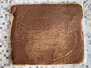 Un pezzo di torta al cioccolato è appoggiato su un bancone piastrellato.
