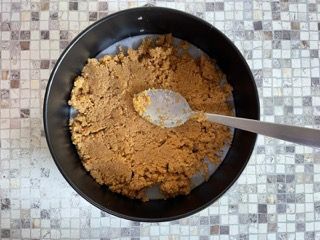 Una ciotola di cibo con un cucchiaio dentro su un tavolo.