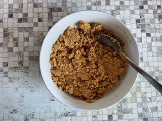Una ciotola di cibo con un cucchiaio dentro su un tavolo.