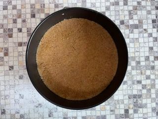 Una padella piena di biscotti Graham è appoggiata su un tavolo piastrellato.