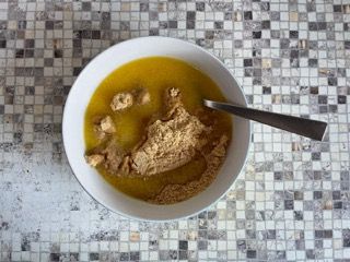 Una ciotola di zuppa con un cucchiaio dentro su un tavolo.
