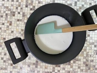 Una padella con dentro una spatola e un cucchiaio di legno.