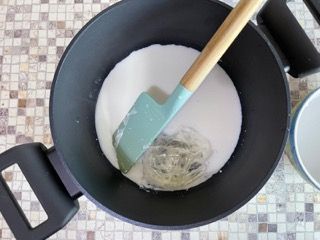 Una pentola con del liquido e una spatola dentro.