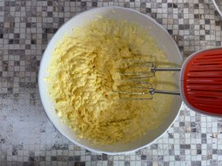 Una ciotola di pastella con dentro un mixer su un tavolo.