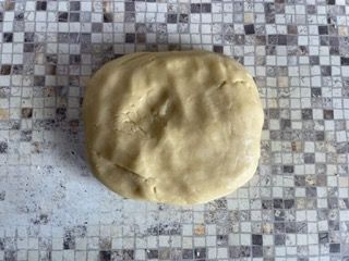 Una palla di pasta è appoggiata su un bancone piastrellato.