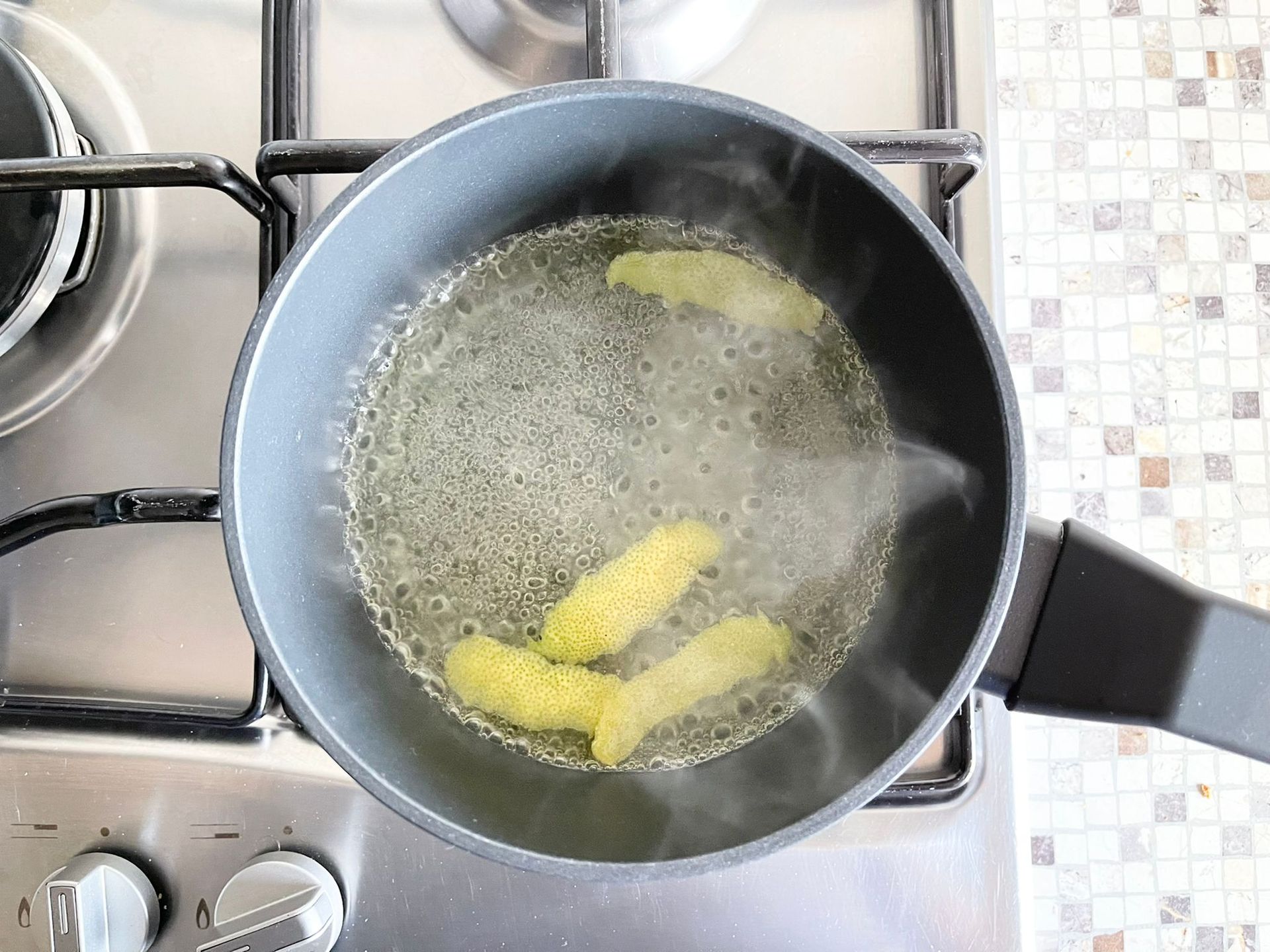 Una pentola di acqua bollente con dentro delle patatine fritte su un fornello.