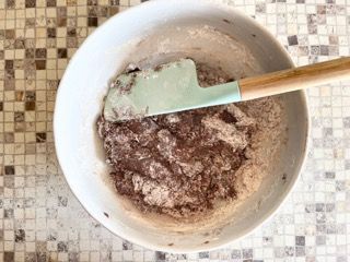 Una ciotola di cibo con una spatola dentro su un tavolo.