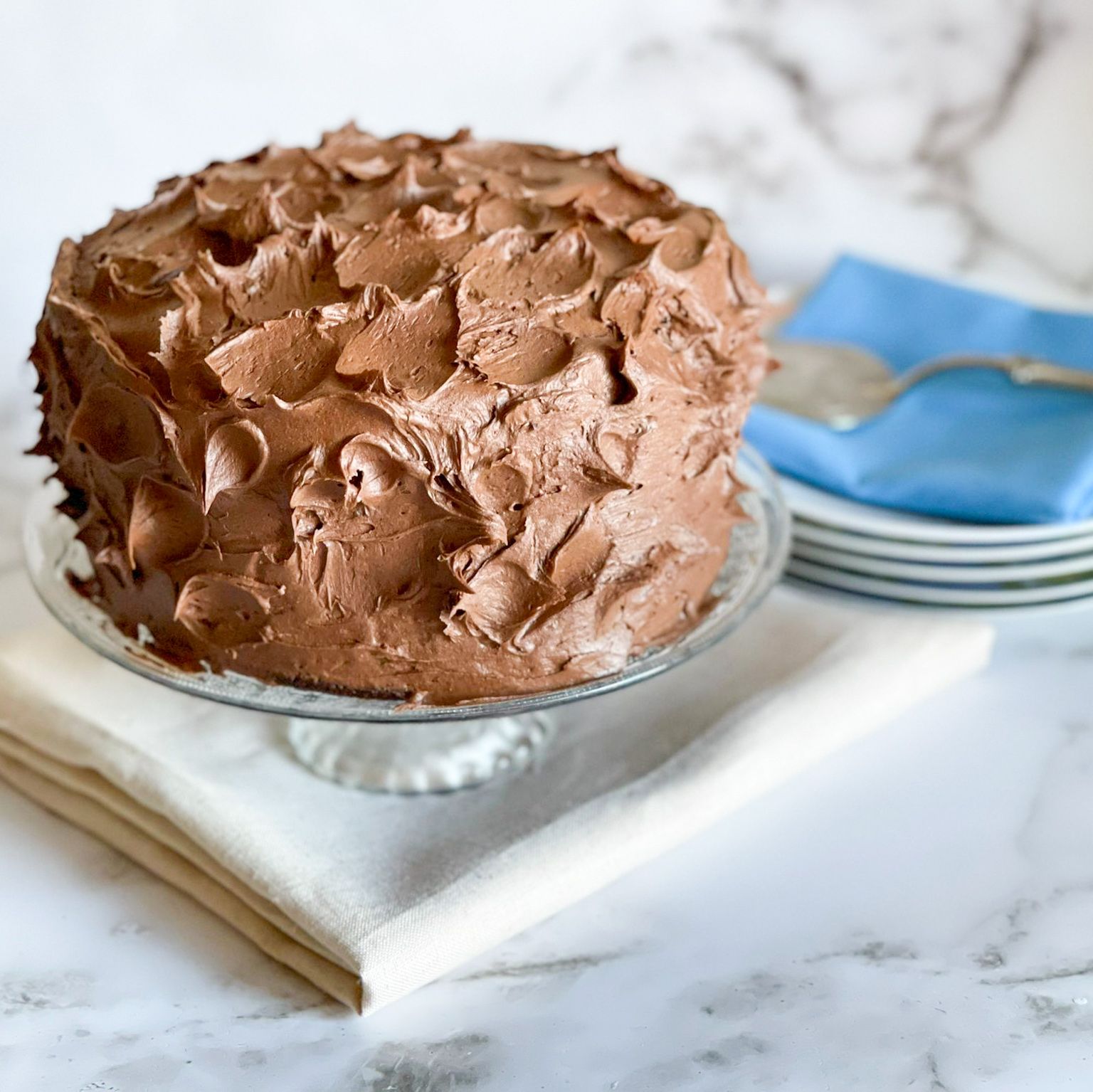 Una torta al cioccolato è su un piatto di vetro su un tavolo